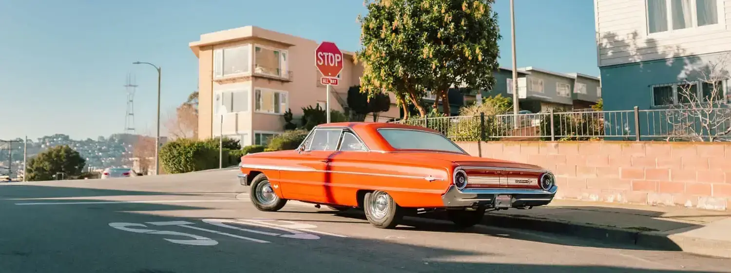 orange classic car parked on a street