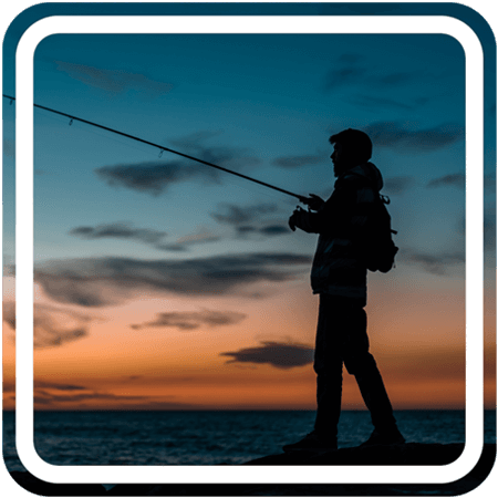 The silhouette of a person fishing against a sunset backdrop