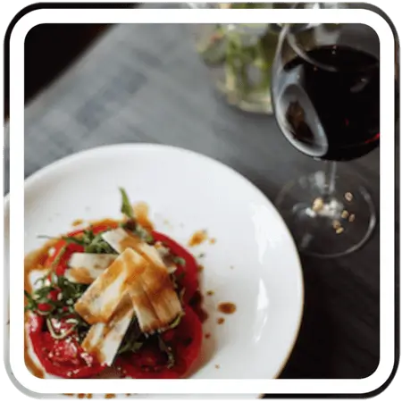 a plate of food with a salad and a glass of wine on a table