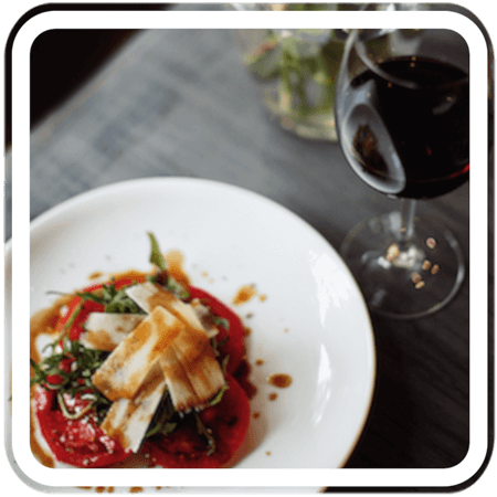 a  plate of food with a salad and a glass of wine on a table