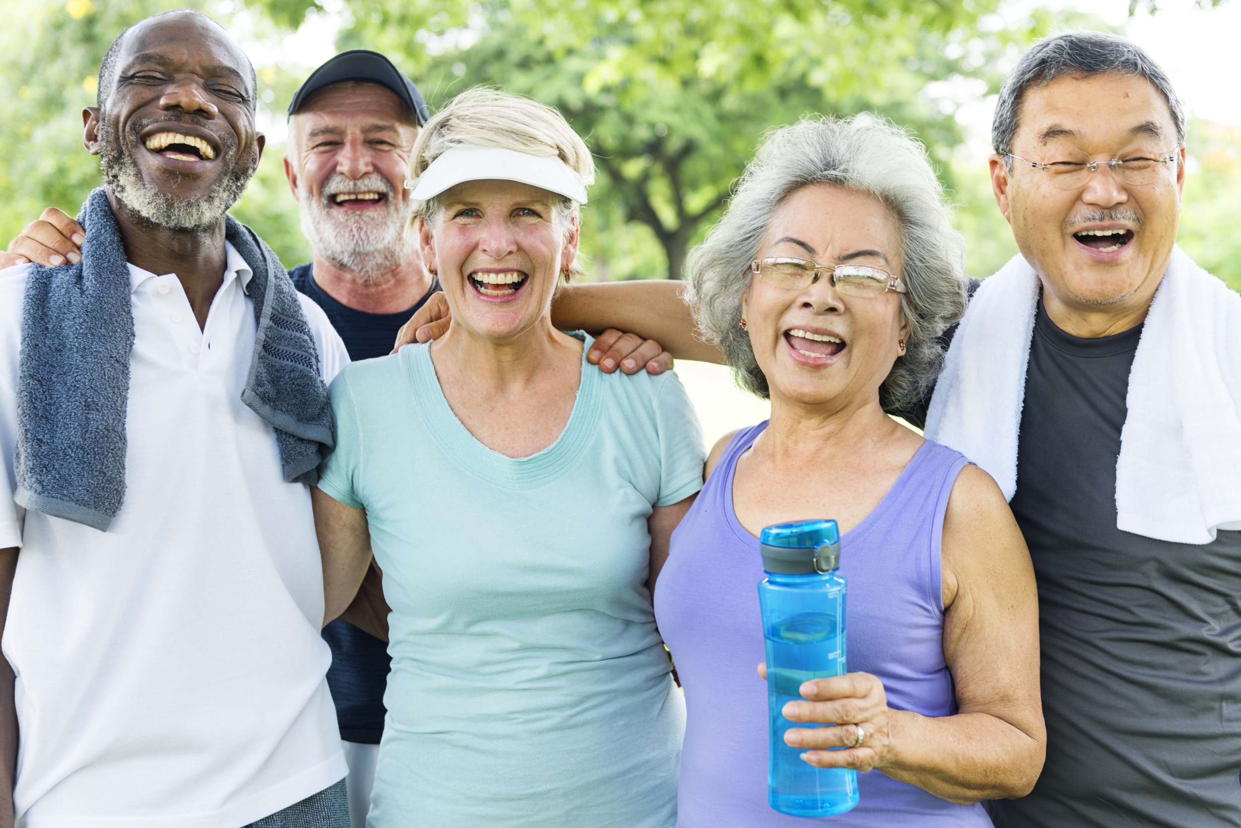 A group of seniors happily smiling and holding water bottles.