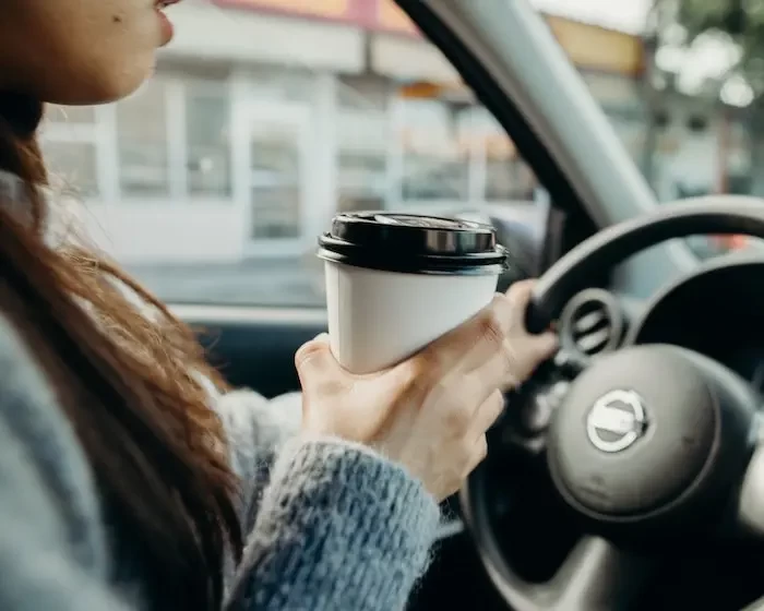  woman with cup driving small