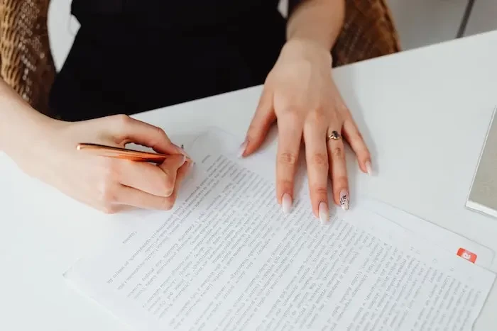  person holding pen writing on a document small