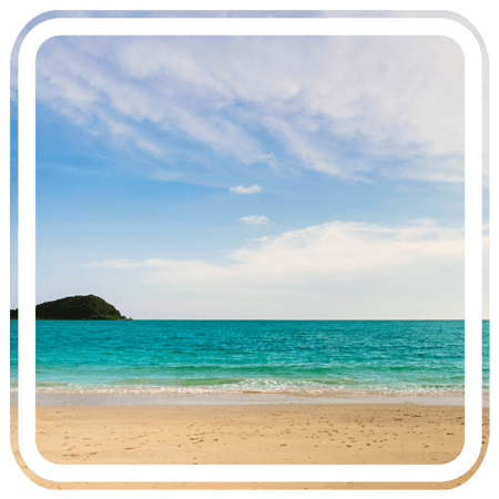 a beautiful beach with turquoise water and a small island in the distance