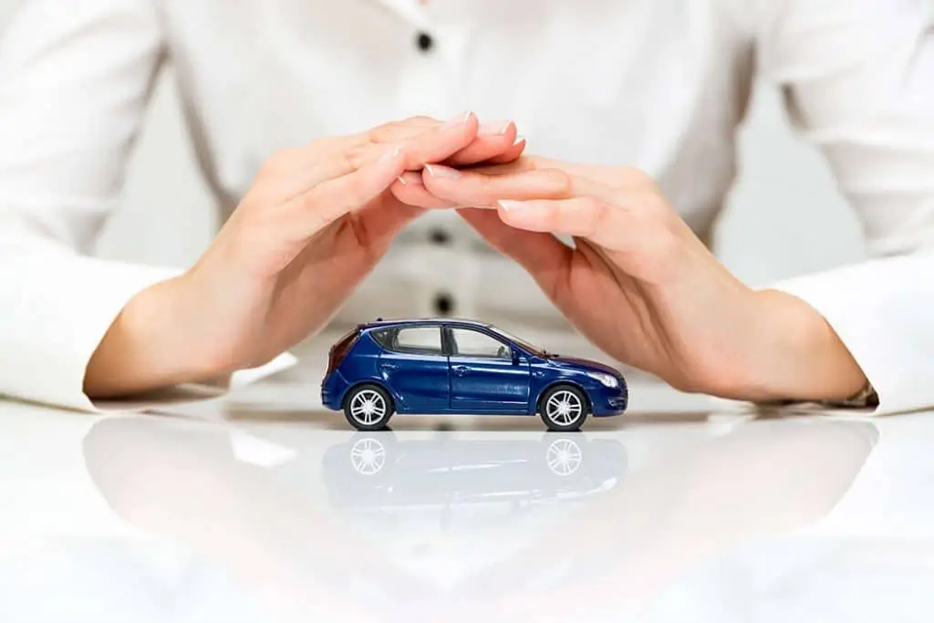 A toy car positioned under two hands