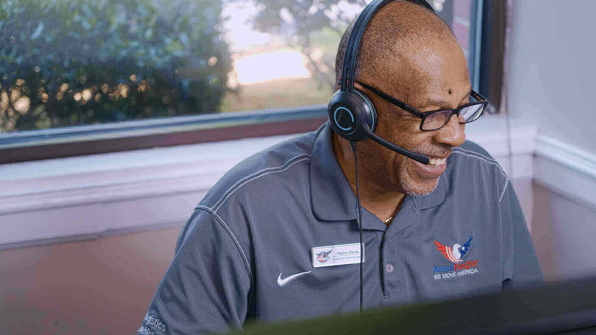an smiling employee of AmeriFreight on a phone call