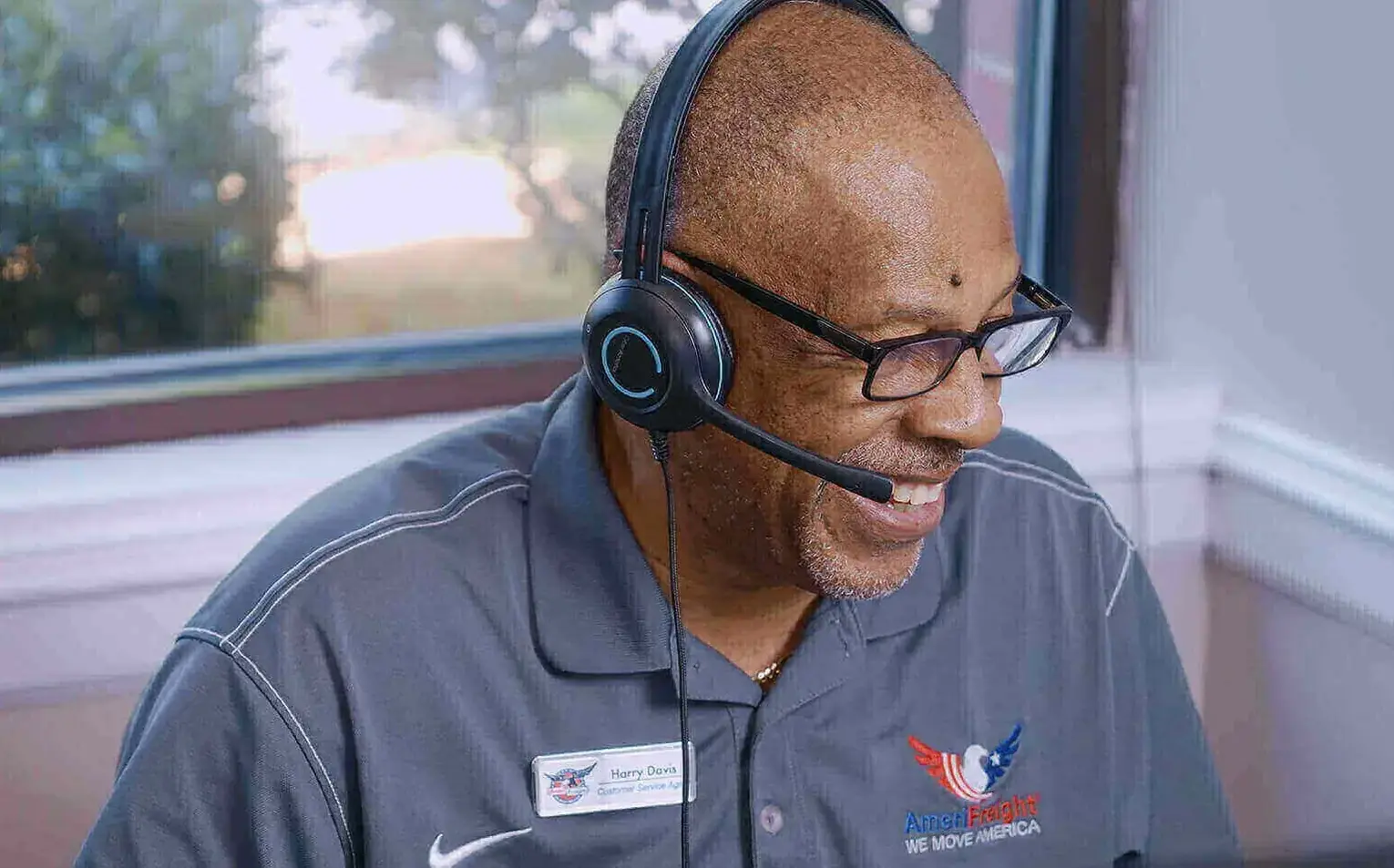 an smiling employee of AmeriFreight on a phone call