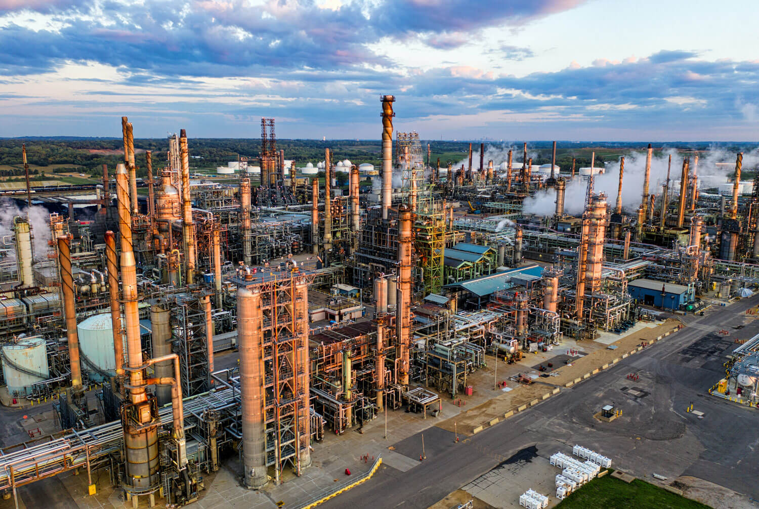 An aerial view of the Pine Bend oil refinery in Rosemount, Minnesota, showing a network of pipes, storage tanks, and industrial buildings.