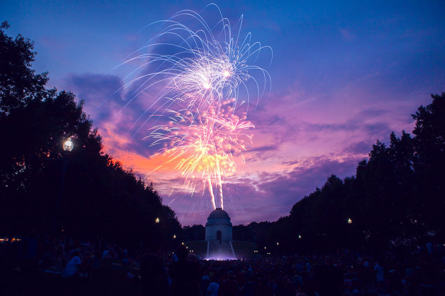 Fireworks light up the night sky in Ohio with a crowd of people watching