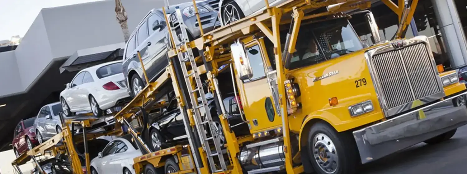 Yellow semi truck transporting cars on top.